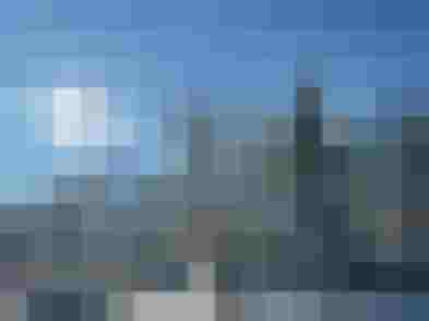 Verschneiter Baum im Sonnenschein vor Bergkulisse