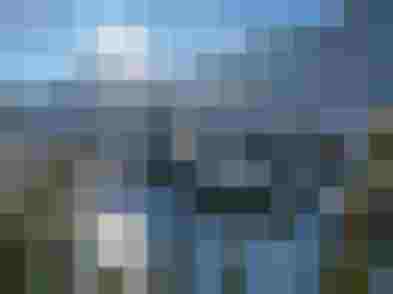 Winter landscape with sun over snowy mountains and houses